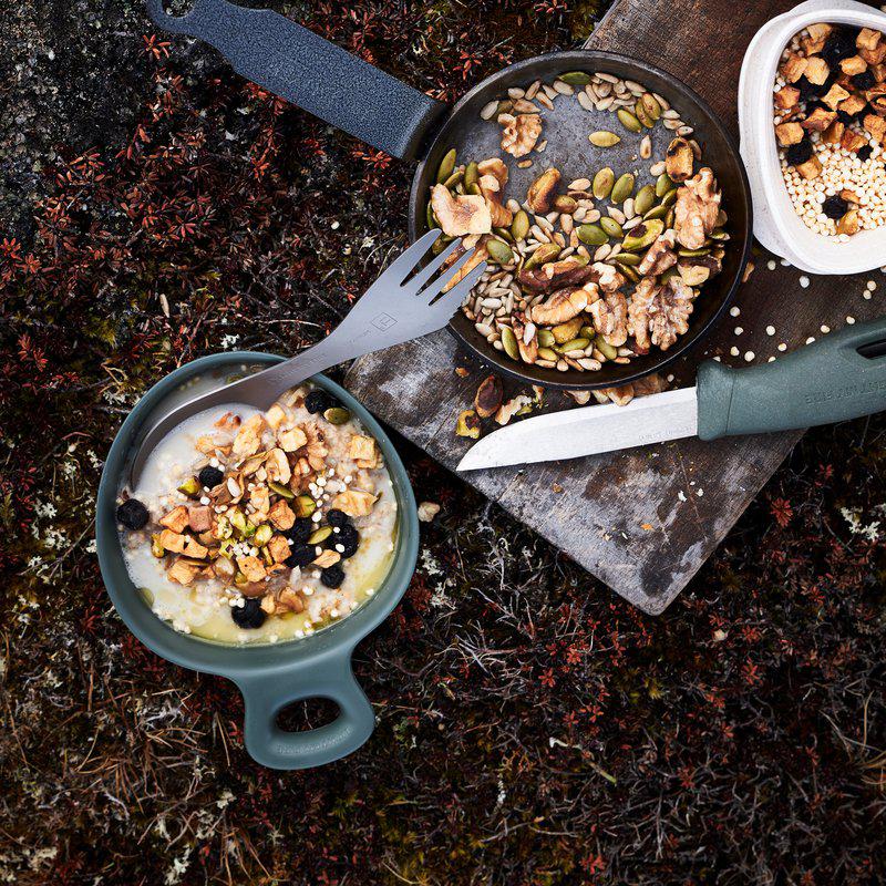 Kvinna äter ur Swedish Kåsa 300ml grön med spork